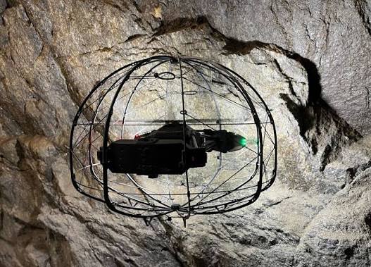 Flybotix ASIO X protected inspection drone near an underground rock face